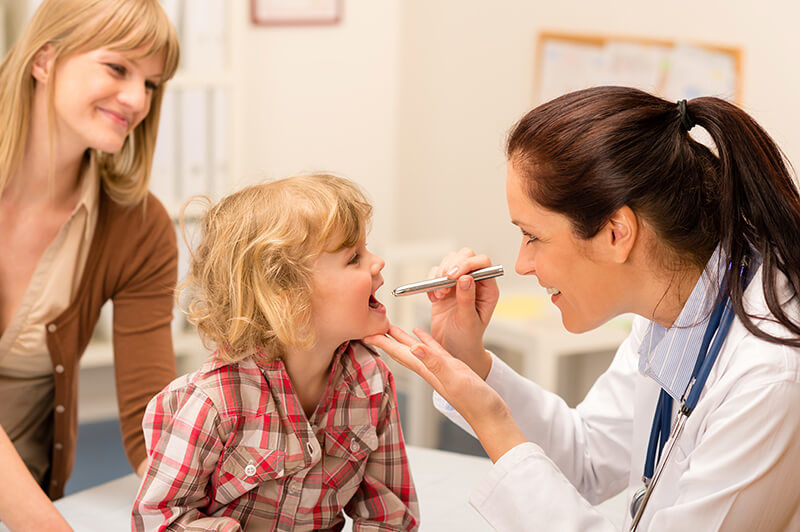 ENT Doctor inspects a child's tonsils and throat
