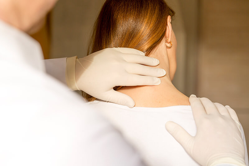 Head and Neck Specialist Surgeon feeling a lump on a female patient's neck