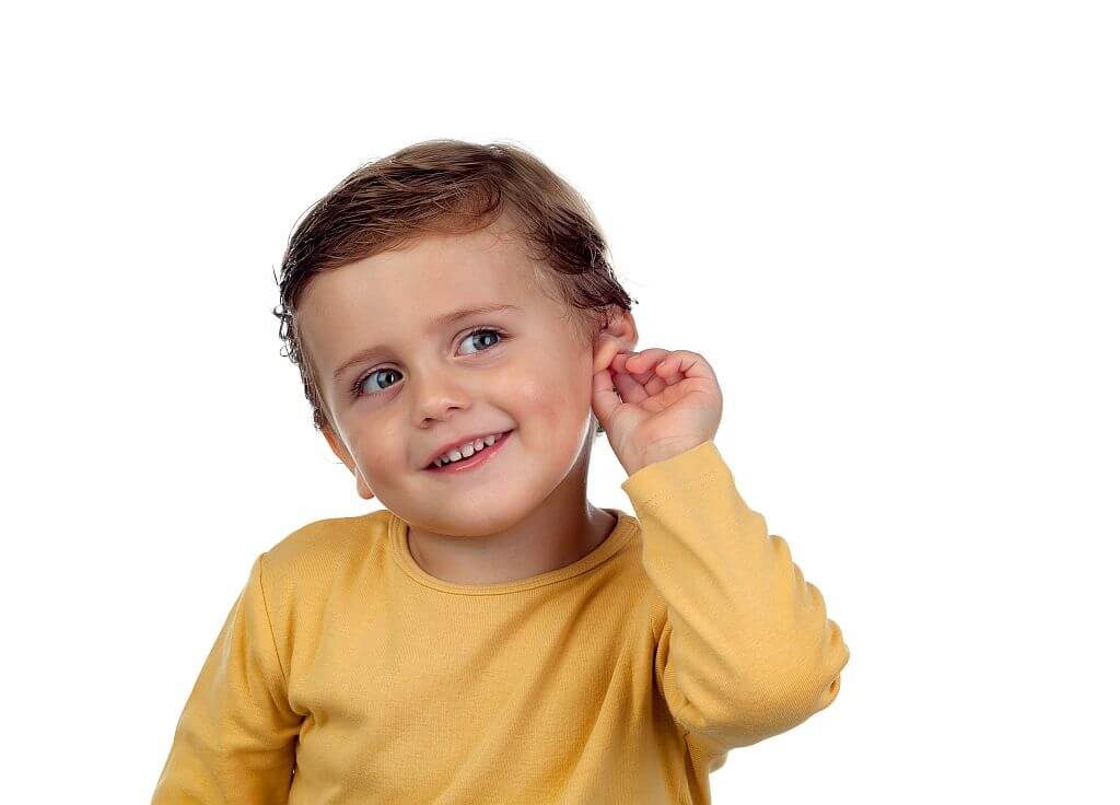 Smiling child touching ear after hearing